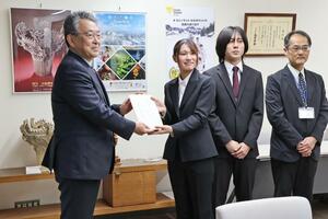 十日町高校定時制の生徒会がバザーの収益を寄贈した贈呈式。左から関口市長、千葉零奈さん、阿部偉冴心さん、岡本仁志教諭＝十日町市役所