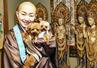 　「副住職」に任命した保護犬のアトム（右）、ビビと共に、観音像の前で写真に納まる高橋美清＝２０２６年２月、群馬県伊勢崎市の心月院