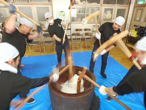 勢いよくきねを振り下ろして餅をつく「東山五人杵搗き餅」=小千谷市南荷頃