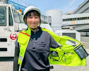 配備された冷却ベストの内側を見せる日航グループの地上業務担当職員=4日午前、羽田空港