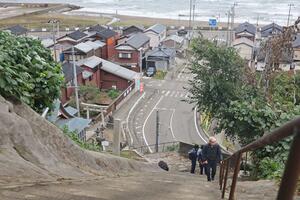 訓練で津波警報の発令を受けて高台に避難する住民=出雲崎町