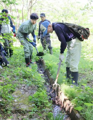 「花坂の棚田」で行われた農業用水路の泥さらい。耕作者が少なくなる中、有志が作業を手伝った=柏崎市高柳町石黒