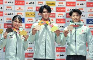 体操の世界選手権で獲得したメダルを手にする(左から)女子の杉原愛子、男子の橋本大輝と角皆友晴=27日、東京都新宿区
