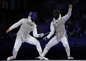 男子フルーレ団体決勝 イタリア選手(左)からポイントを奪い、ガッツポーズする飯村一輝=パリ(共同)