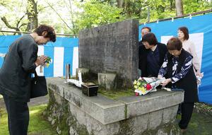戦没者の碑に手を合わせる遺族ら=23日、長岡市西片貝町