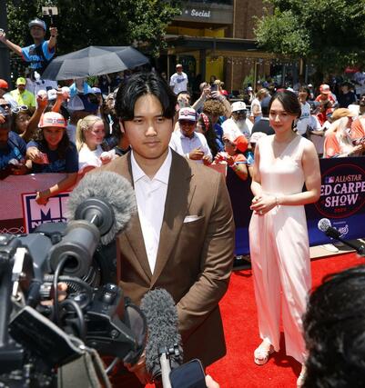 米大リーグ、オールスター戦の試合前恒例行事、レッドカーペットショーで取材に応じるドジャース・大谷翔平。奥は妻真美子さん＝アーリントン（共同）