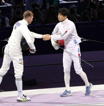 男子エペ団体決勝　日本－ハンガリー　第３試合を終え、相手選手と握手する古俣聖（右）＝パリ（新潟日報社写真映像部・新井田悠）