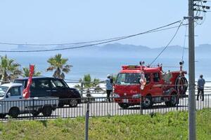 津波警報が発令され、高台から海を見る人=30日午前、福島県いわき市の四倉海岸
