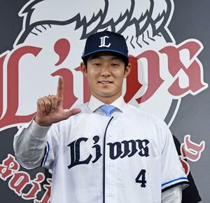 日本ハムから西武に移籍し、記者会見でポーズをとる石井=26日、埼玉県所沢市