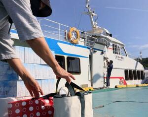 魚島に向かう船に生活用品を積み込む利用客=5月、愛媛県上島町の弓削港