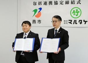 協定締結式に臨むマルタケの茂木稔之社長（右）と、燕市の佐野大輔市長＝燕市吉田西太田