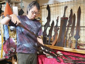 アニメなどに登場する武器のようなピザカッターを作っている田辺勇人さん=柏崎市東本町3
