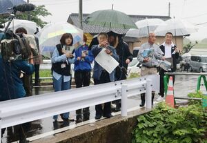 絵本作りに向けて、県北豪雨で被災した住民に話を聞きながら集落を歩く新潟デザイン専門学校生ら=村上市小岩内
