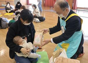 生後3〜4カ月健診に訪れた親子に特別栽培米が手渡された=佐渡市新穂瓜生屋