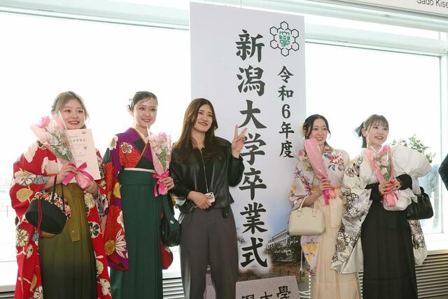 記念撮影する新潟大の卒業生。４月からは、それぞれの道を歩む＝３月２４日、新潟市中央区