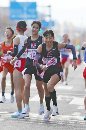 女子 新潟明訓の1区橋本和叶が2区石川桃子にたすきをつなぐ=京都市内の第1中継所