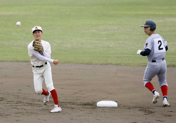 ２回表１死一、三塁、上越総合技術木本の内野ゴロで一走田中を封殺し一塁に投げ併殺にする遊撃手巻渕（左）＝４月２８日、柏崎市佐藤池野球場