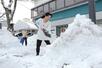 大雪から一夜明け、除雪に追われる市民＝２５日、新潟市中央区笹口２