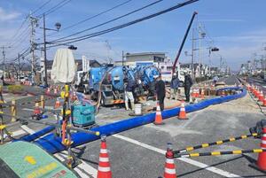 岡山県総社市内で発生した下水道破損事故の現場付近で続けられる復旧作業=24日(同市提供)