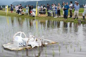 除草ロボットの動きを確認する参加者＝津南町下船渡