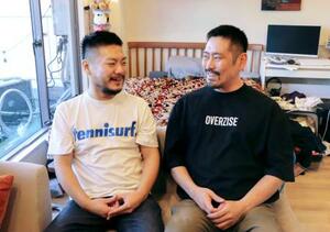 　自宅で会話するザン・クリストファーさん（左）と鹿島真人さん＝１９日、東京都内