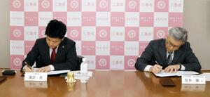 包括連携協定締結の書面に署名する滝沢亮市長(左)と坂井操社長=三条市役所