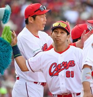 　２０２４年５月、巨人戦に勝利し広島の新井監督（左）とタッチを交わす羽月隆太郎内野手＝マツダ