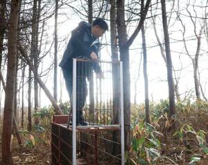 箱わなのセンサーを点検する太田和哉さん=11月27日、北海道松前町