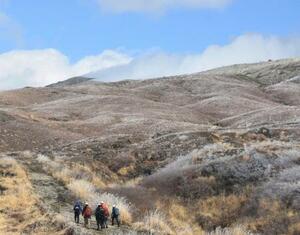 　熊本県・阿蘇山の中岳火口付近（奥）に向かう県警の警察官と消防隊員ら＝２１日午後１時２５分