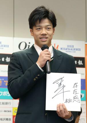 新入団選手会見で色紙に「存在感」としたため、意気込みを語る石山愛輝投手（中越高・新潟市西蒲区出身）＝エコスタ