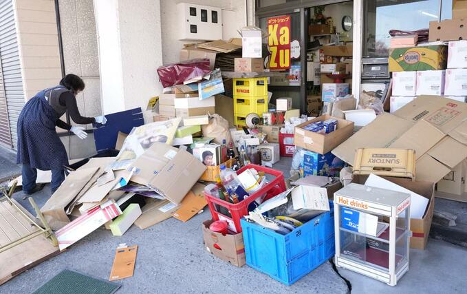 強い地震があった青森県八戸市で商品が散乱した酒屋を片付ける女性＝９日午前１１時４２分