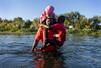 子どもを抱え、メキシコ・シウダアクニャからリオグランデ川を渡ってアメリカ・テキサス州に向かうハイチ人男性＝２０２１年（ゲッティ＝共同）