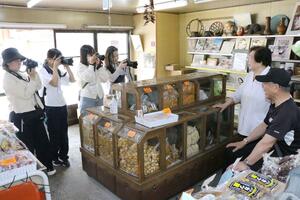 新潟県内の高校生の撮影大会で被写体にカメラを向ける参加生徒=6月7日、新潟市中央区古町通10