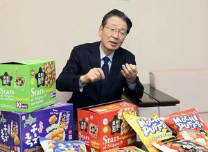 海外向けパッケージのふんわり名人などについて説明する越後製菓の星野一郎会長=小千谷市