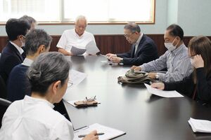 品田宏夫村長（奥）に質問状を渡した市民団体のメンバーら＝刈羽村役場