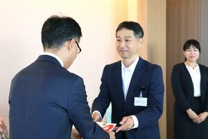 目録を手渡す「えくぼの会」の細木広之会長(中央)=新潟市中央区