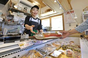 接客をする秋間愛さん。お客さんとの会話も楽しんでいる=13日、新潟市西区