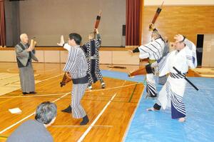 太田喜一郎会長（左）の指導で振り付けの稽古をする出演者ら＝１５日、南魚沼市塩沢