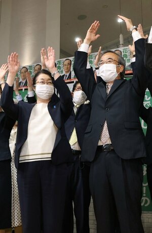 新潟県知事選で当選確実の報を受け、万歳する花角英世氏（右）。左は田枝夫人＝５月２９日午後８時過ぎ、新潟市中央区