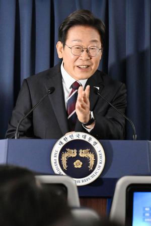 G7サミットの開催地、カナダへ向かう韓国の政府専用機内で、記者団の質問に答える李在明大統領=16日(聯合=共同)