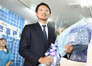 知事失職に伴う兵庫県知事選で再選を決め、花束を手に笑顔の斎藤元彦氏=11月17日夜、神戸市