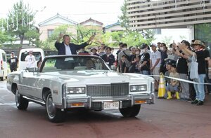 ジャイアント馬場さんの愛車キャデラックの常設展示を前に、グレート小鹿さんらが乗車して行ったパレード=三条市