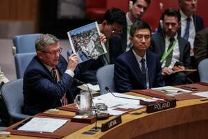 12日、国連安全保障理事会の緊急会合で写真を示すポーランド代表=米ニューヨーク(ロイター=共同)