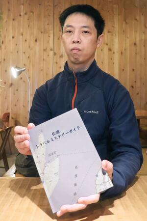 「佐渡トラベルミステリーガイド」を自費出版した滝澤卓朗さん=佐渡市羽茂大崎
