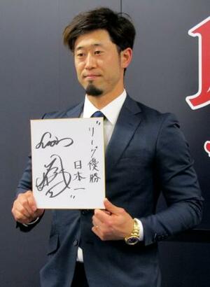 　契約更改交渉を終え、来季の抱負を記した色紙を掲げる西武・外崎＝５日、埼玉県所沢市