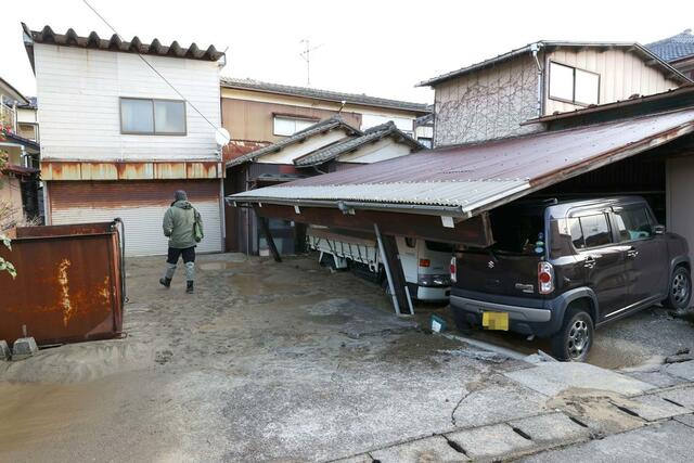 車両に屋根が覆いかぶさった住宅＝１月２日、新潟市西区