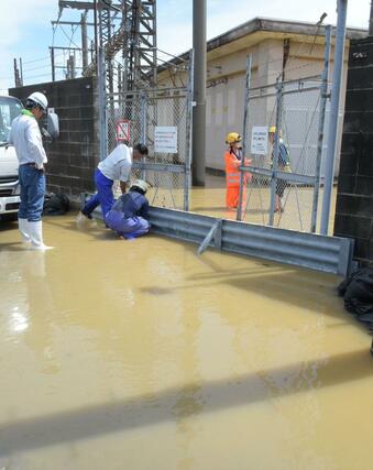 大量の雨水や近隣の貯水池からあふれ出した水で浸水した、えちごトキめき鉄道直江津変電所。浸水を防ぐ入り口の板を乗り越えて、道路から水が入ったとみられる=3日、上越市国府4