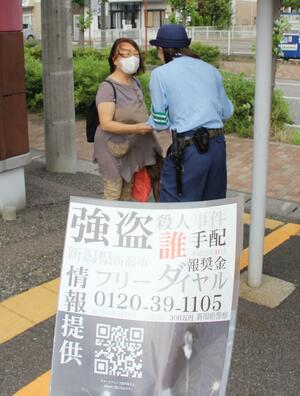 2009年の強盗殺人事件で情報提供を呼びかける警察官=29日、新潟市東区