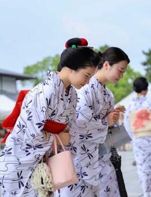 「お千度」で芸の上達や無病息災を祈願する浴衣姿の舞妓や芸妓=3日午前、京都市東山区の八坂神社