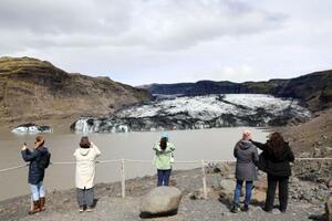 　アイスランド・レイキャビク郊外で、氷河と湖を見る観光客ら＝６月（共同）